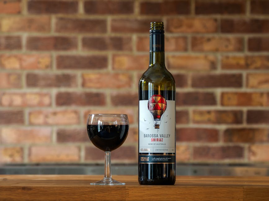 Barossa Valley wineries Shiraz red wine in glass with vineyard backdrop