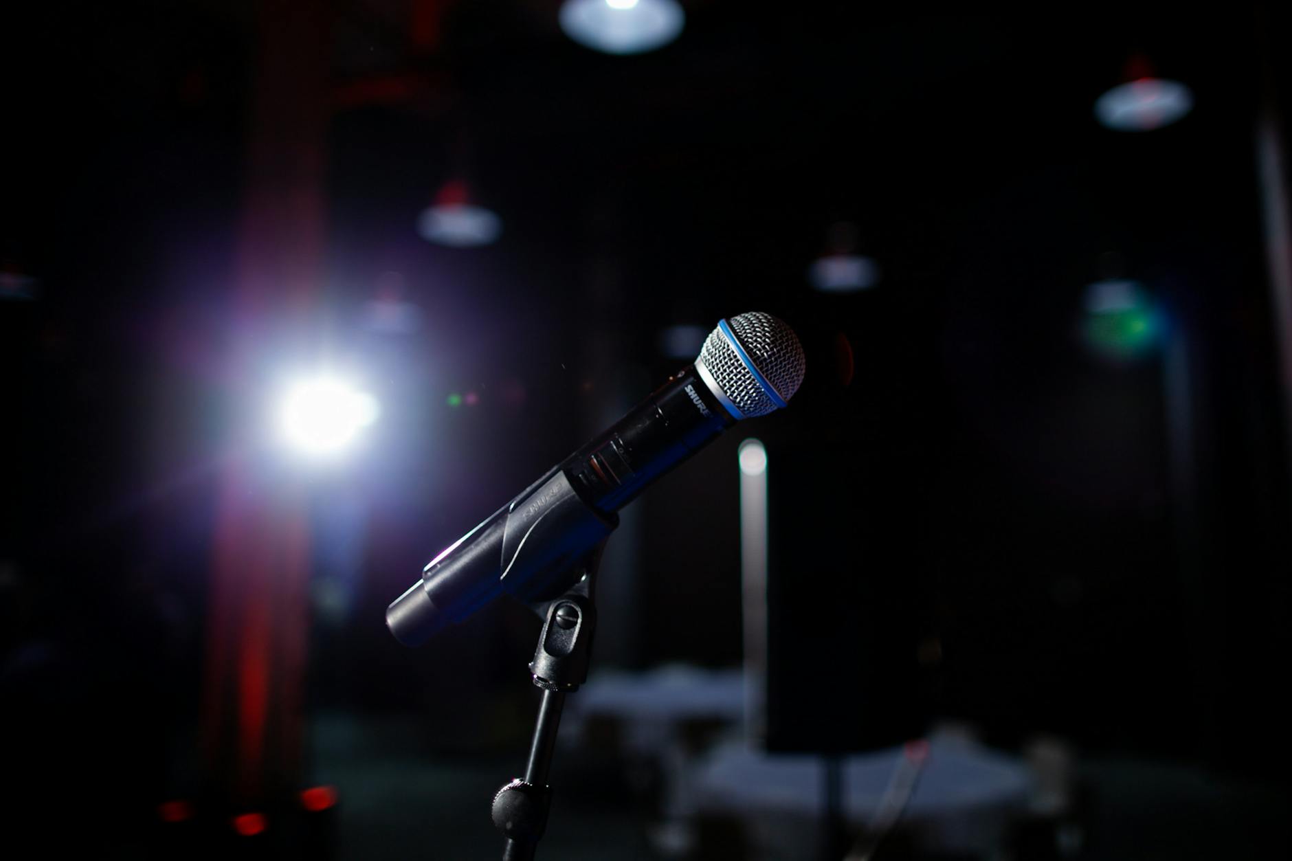 Stand-up comedian performing at an Adelaide comedy venue with microphone