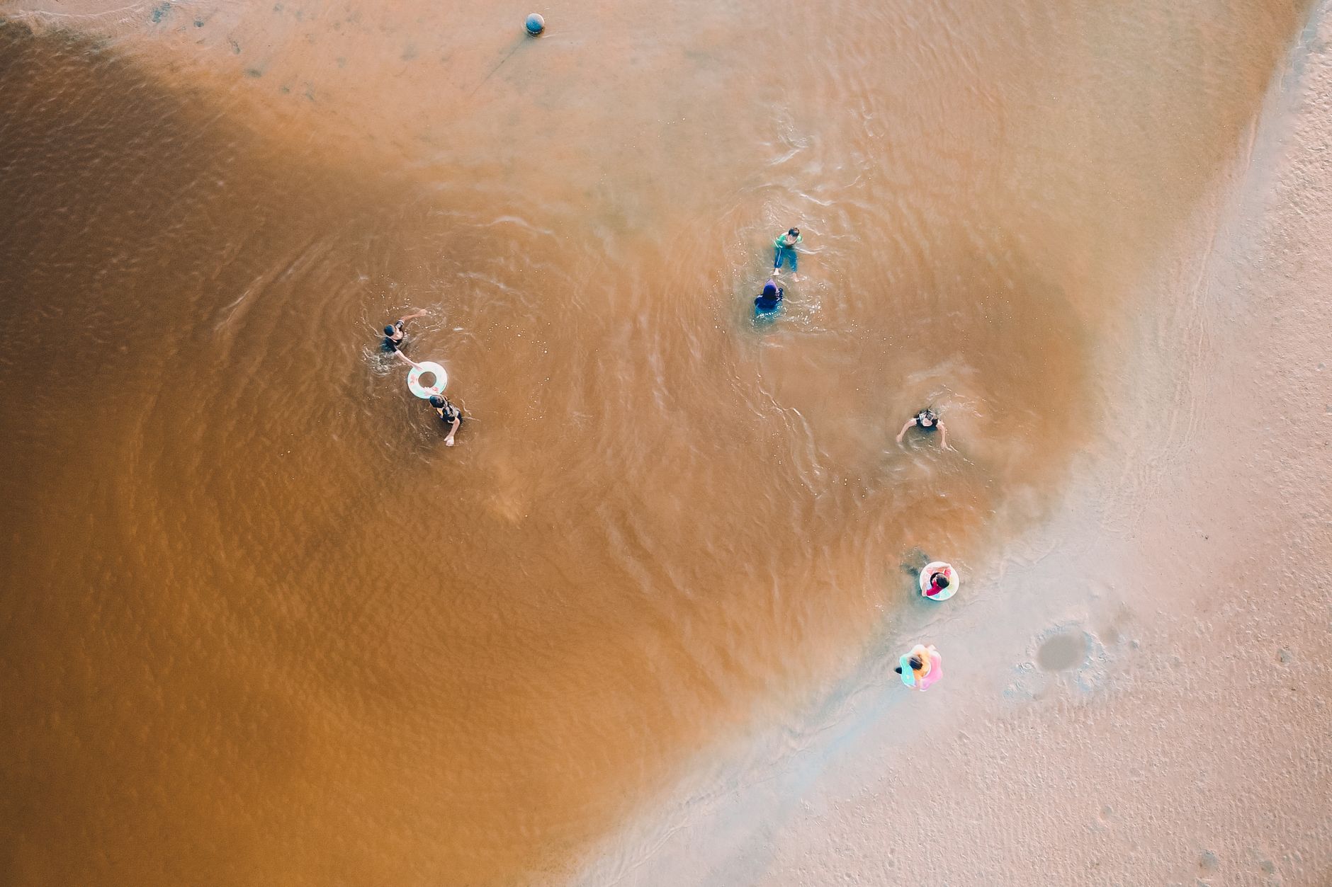 A family swimming in calm shallow water at an Adelaide beach
