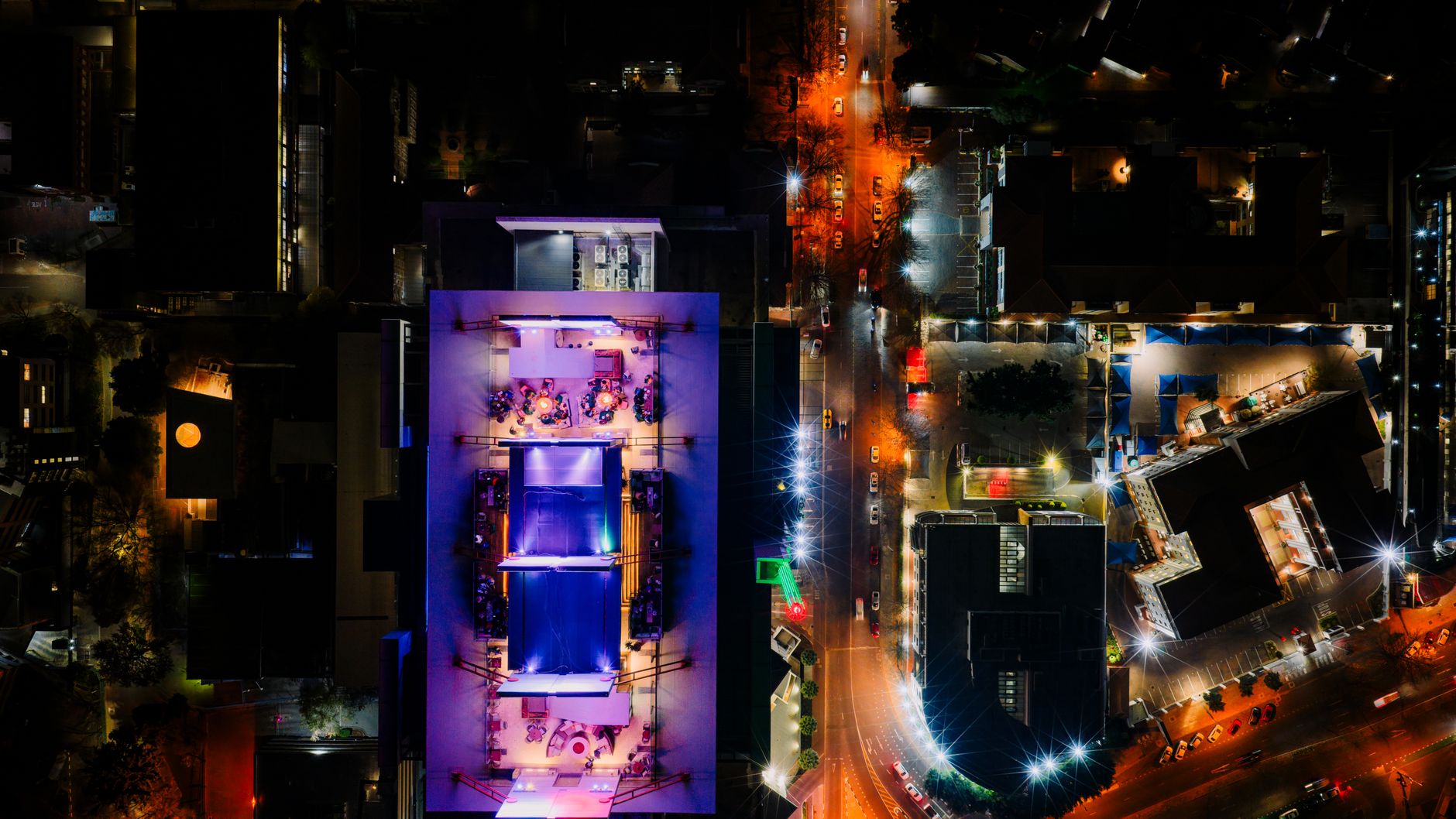 A rooftop cocktail bar at night with city lights behind, an upmarket Adelaide nightlife spot