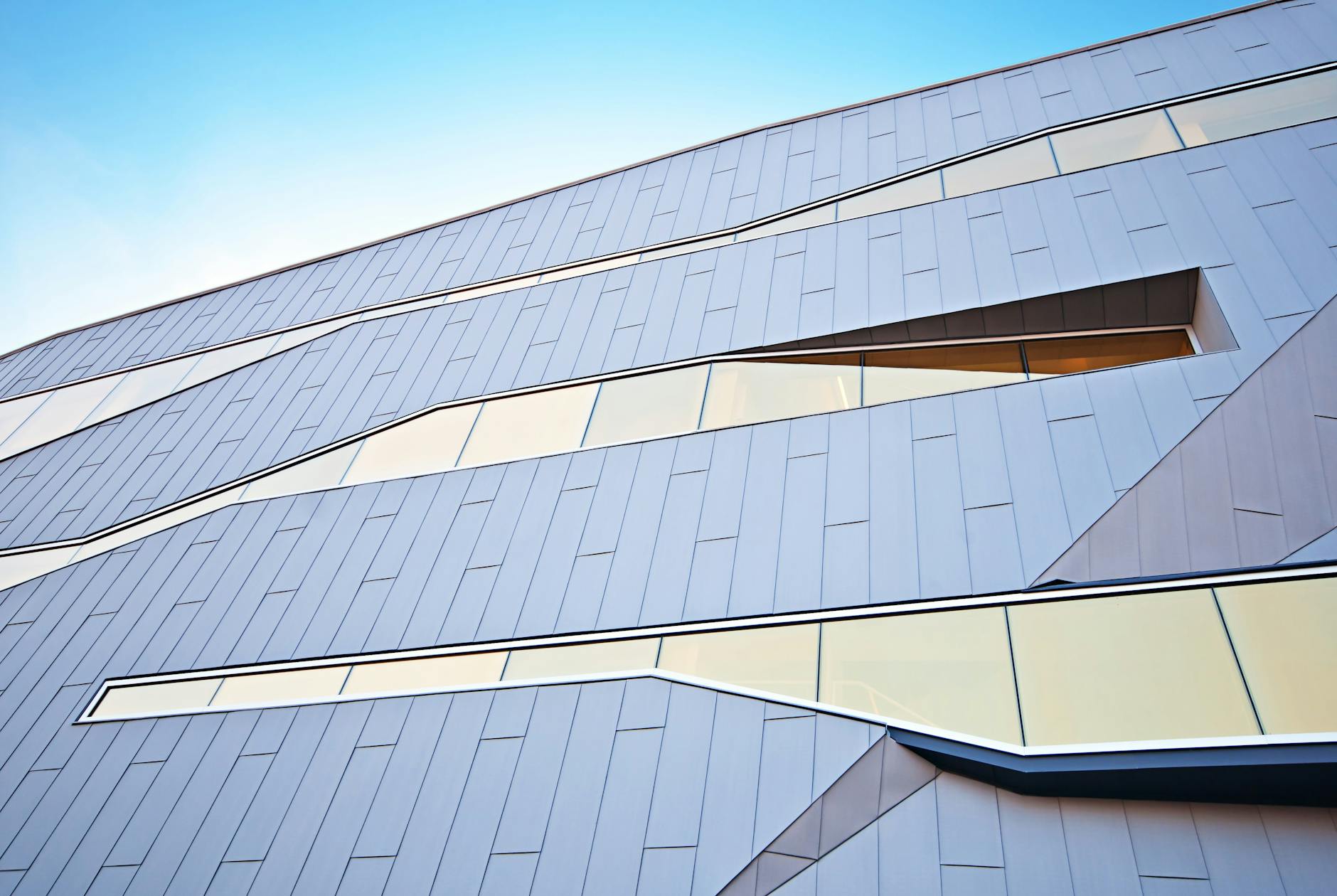 Modern building with an angular perforated metal facade, evoking Adelaide's SAHMRI on the Riverbank
