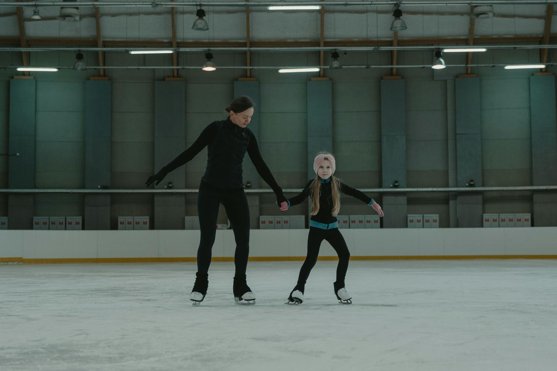 A family ice skating at an indoor rink during the school holidays