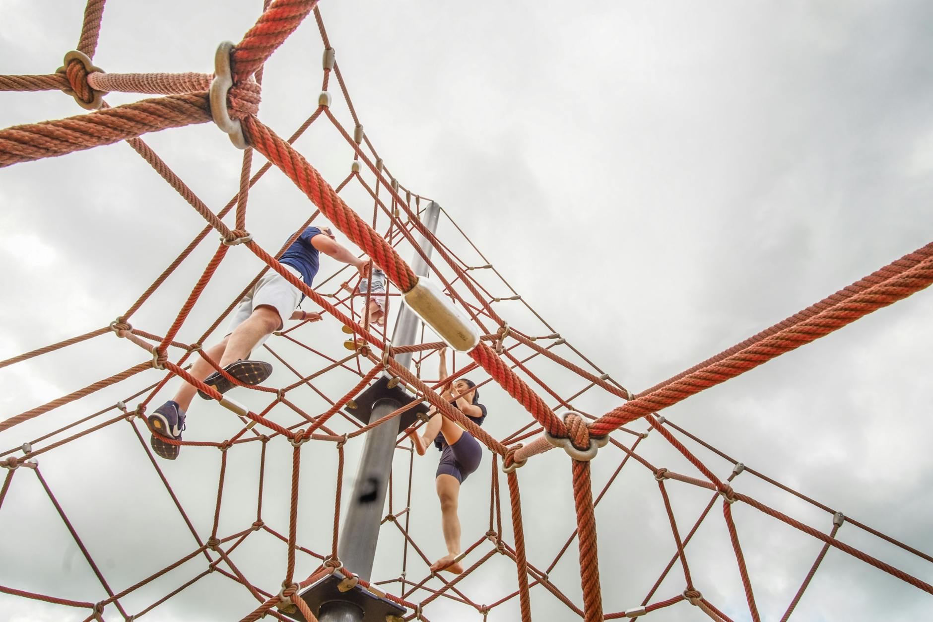 Kids climbing at an outdoor nature playground in autumn
