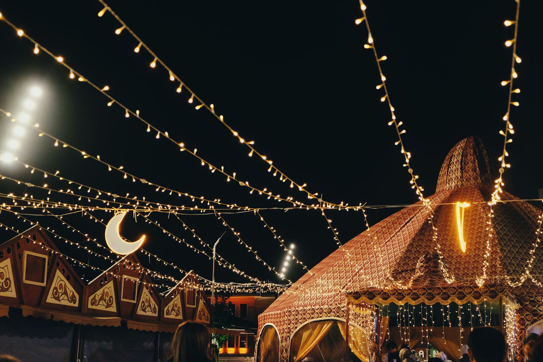 An outdoor festival at night in Adelaide with crowds and lights