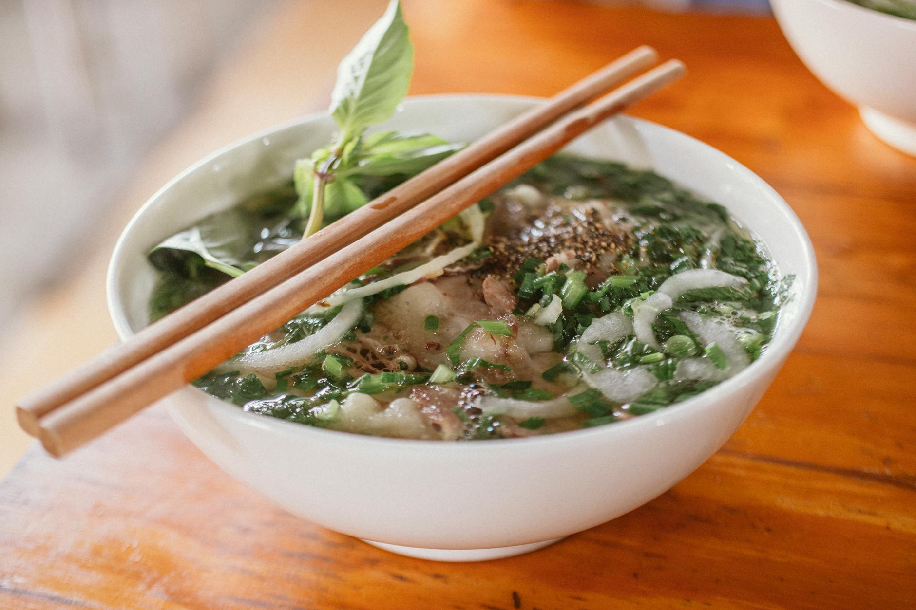 A steaming bowl of Vietnamese pho with herbs, an Adelaide favourite