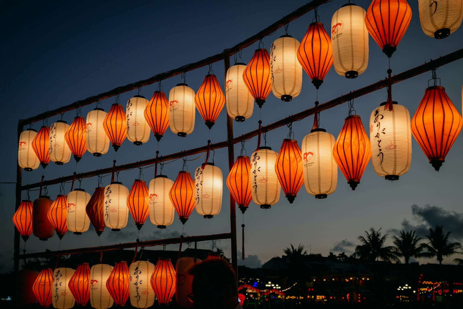 Paper lanterns glowing against the night sky, evoking the OzAsia Festival Moon Lantern Trail