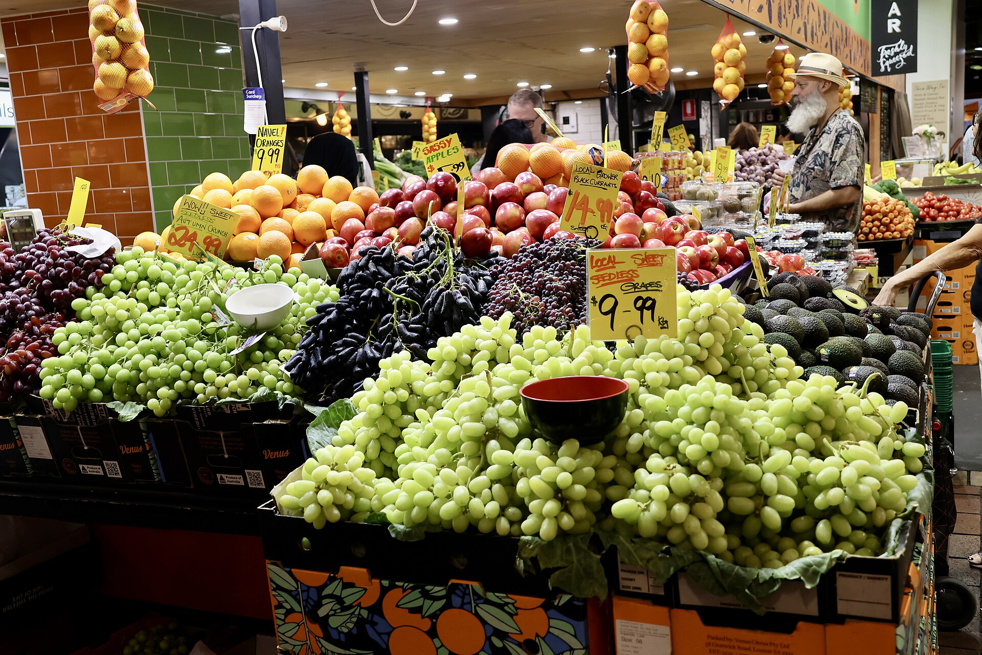 Fruit stalls with handwritten price signs inside the Adelaide Central Market
