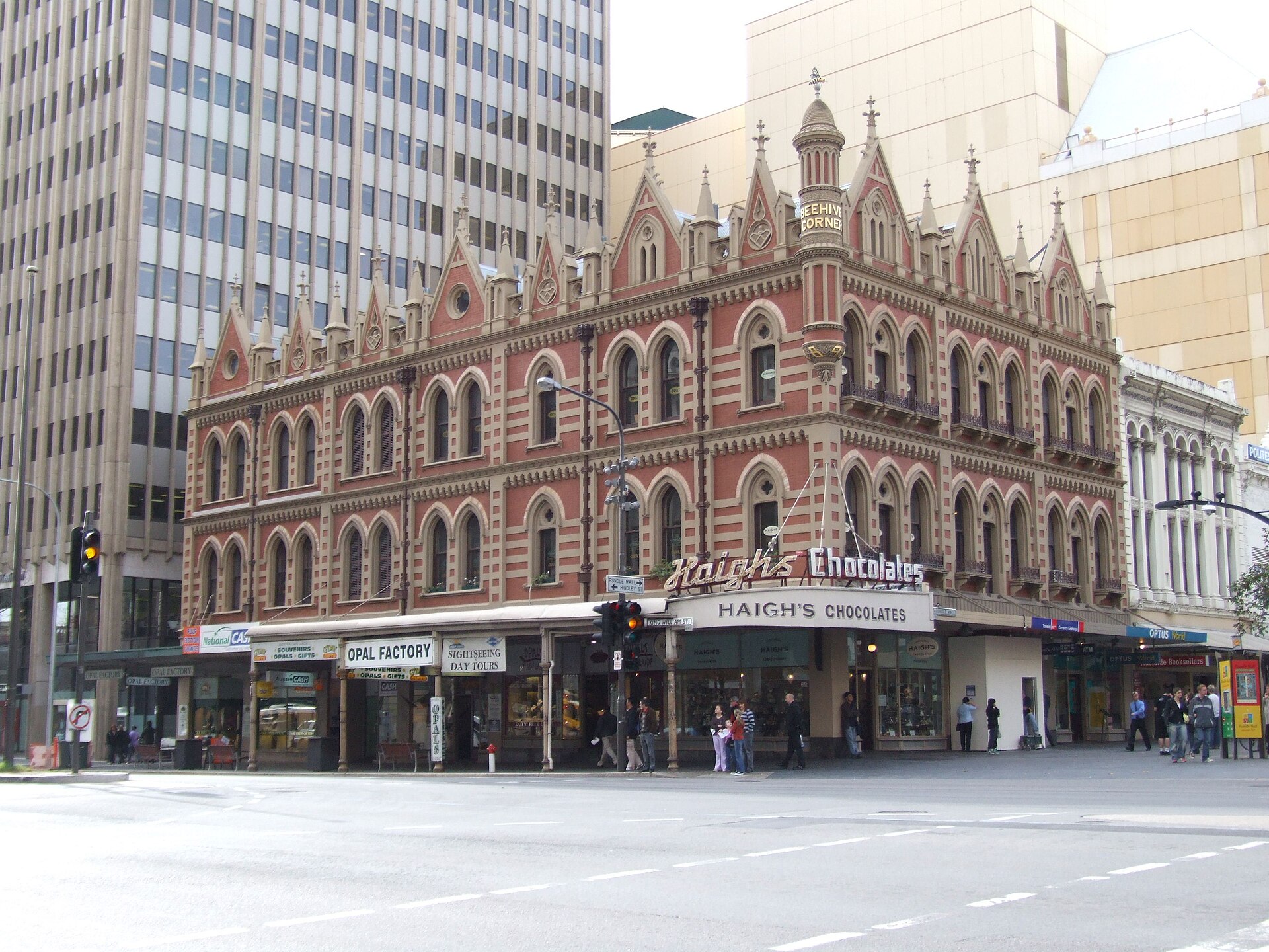 The red-and-cream brick Gothic facade of Beehive Corner with the Haigh's Chocolates shopfront at street level