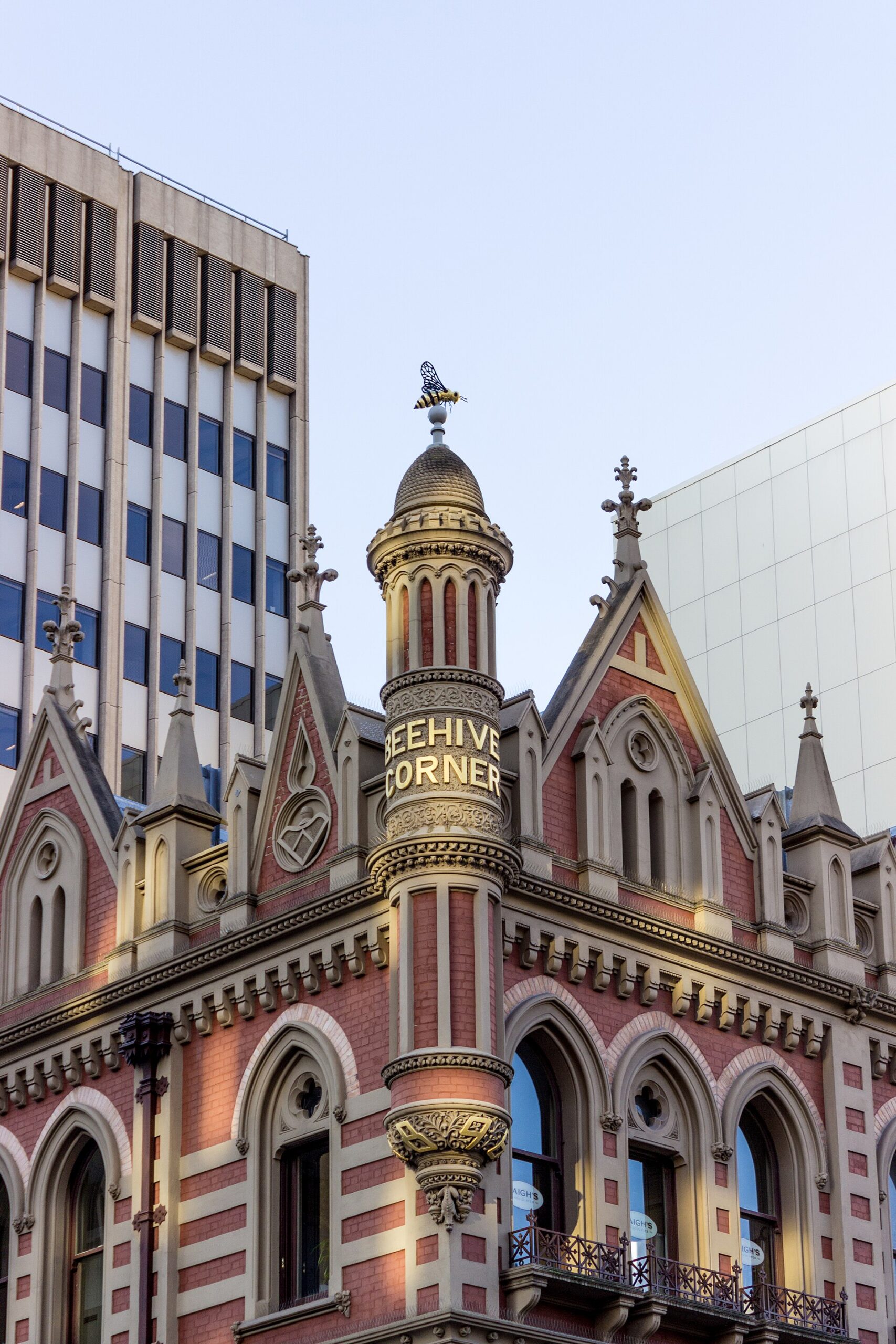 Close view of the Beehive Corner turret with a striped metal bee perched on the ball finial above its dome