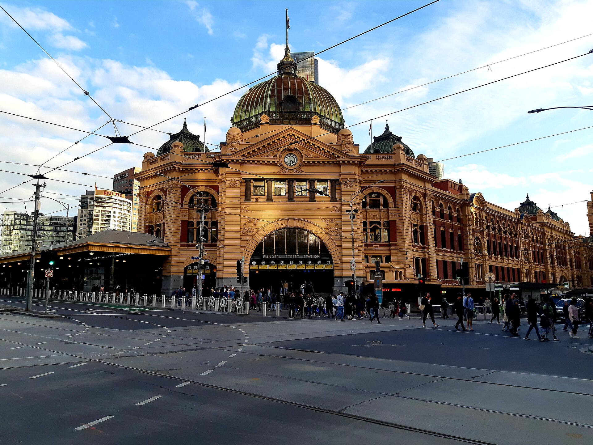 Flinders Street Station in Melbourne with its yellow facade and green dome at a busy intersection