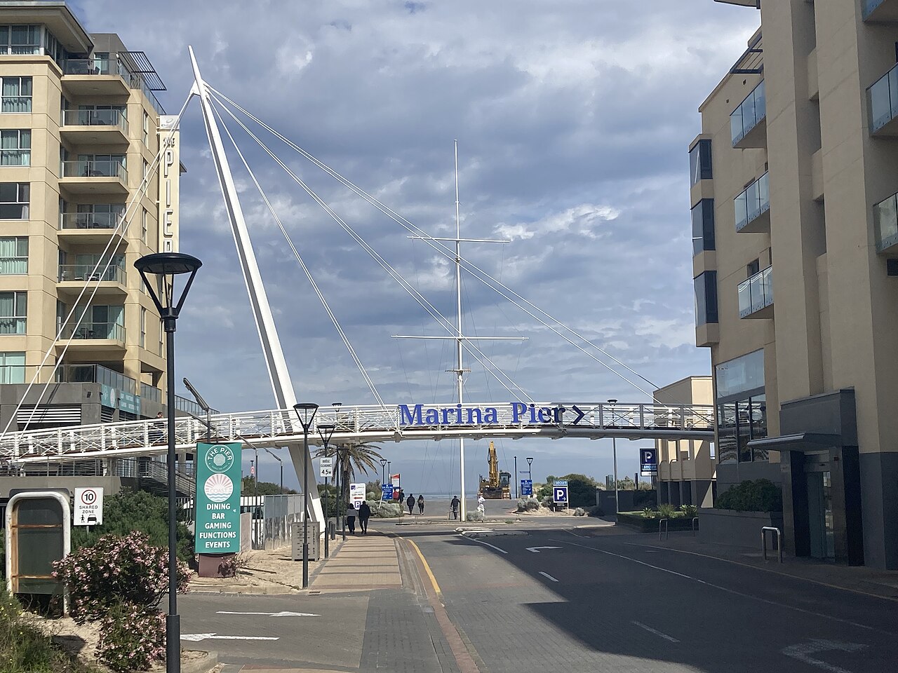 The Marina Pier footbridge and walkway at Holdfast Shores in Glenelg, lined with apartment buildings