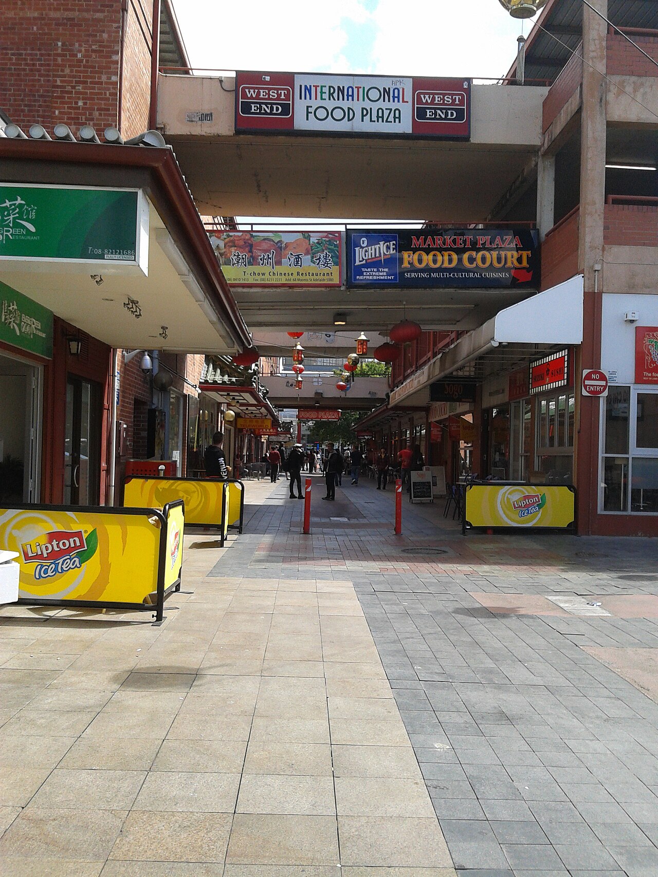 The paved pedestrian lane of Moonta Street in Adelaide's Chinatown, with food court signs and shopfronts along both sides