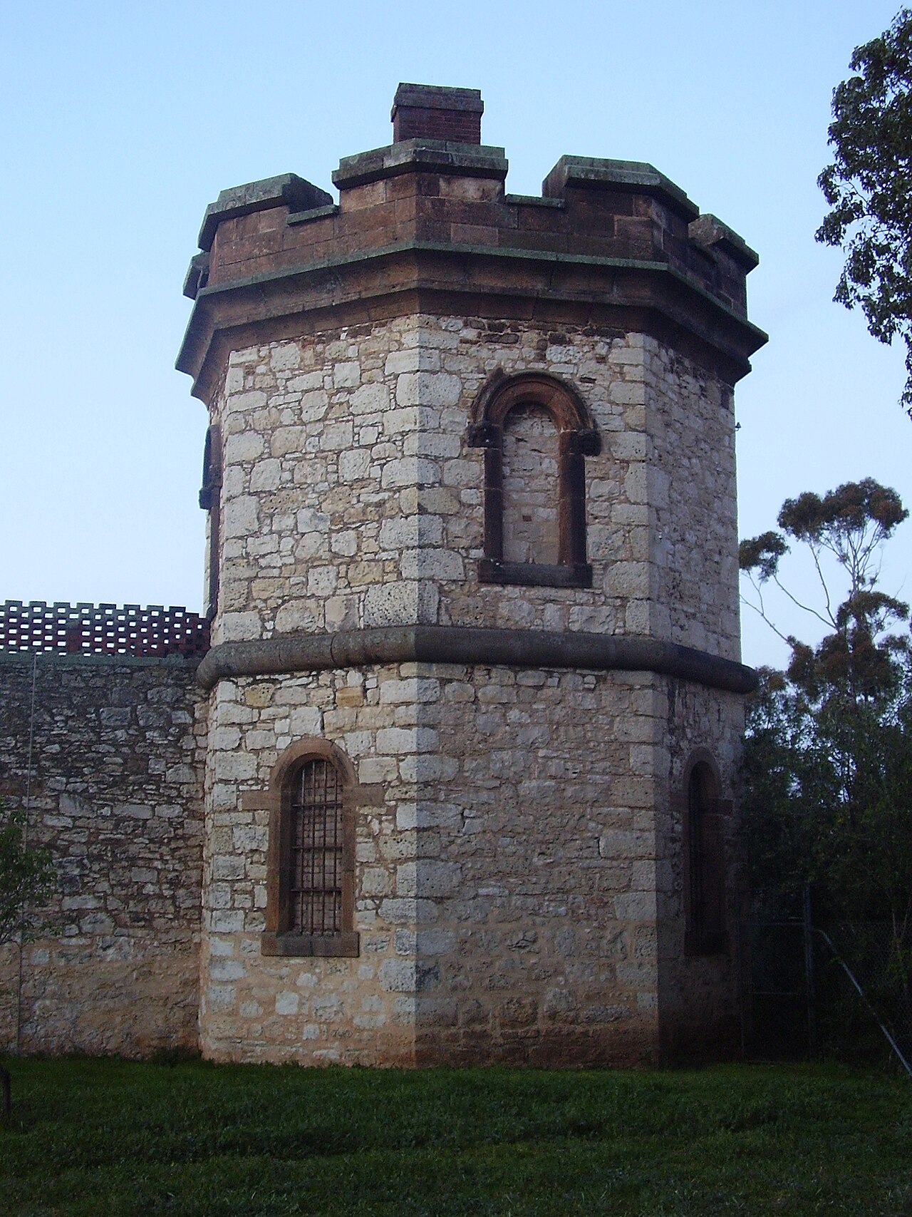 A castellated sandstone tower with small arched windows set into the outer wall of the Adelaide Gaol