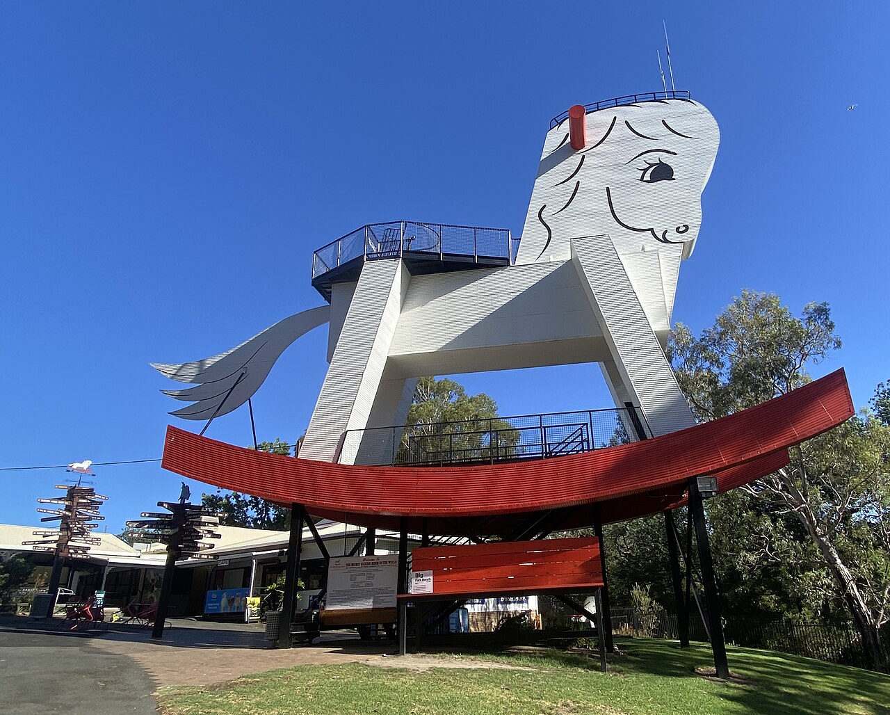 The giant white Big Rocking Horse in Gumeracha, with a red rocker base and viewing platforms, against a clear blue sky
