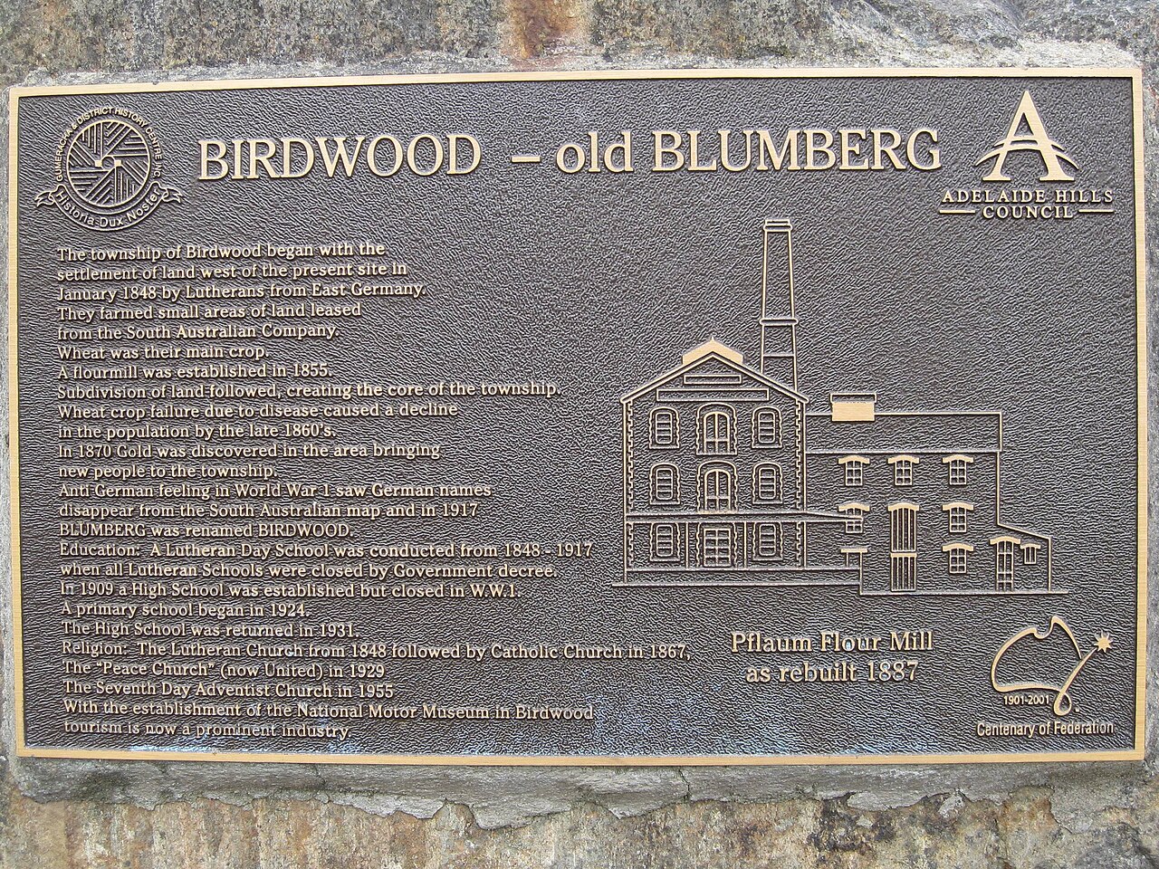 A bronze plaque titled Birdwood - old Blumberg, describing the town's Lutheran settlement in 1848 and its renaming in 1917, with a relief of the Pflaum flour mill